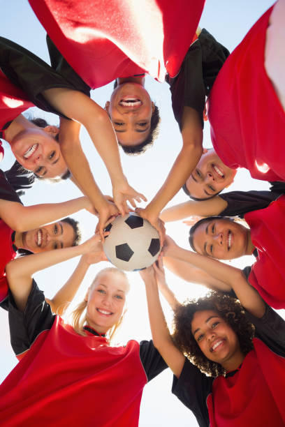 istock Soccer team with ball forming huddle against sky 843499338