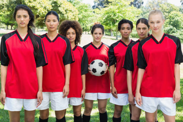 istock Female soccer team with ball at park 843499478