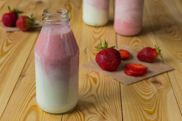 istock Smoothie with strawberry in bottles on wooden table 843505632