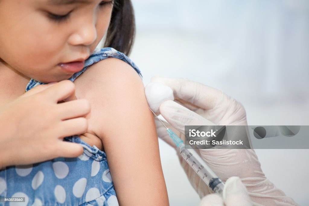 Doctor injecting vaccination in arm of asian little child girl Doctor injecting vaccination in arm of asian little child girl,healthy and medical concept Child Stock Photo