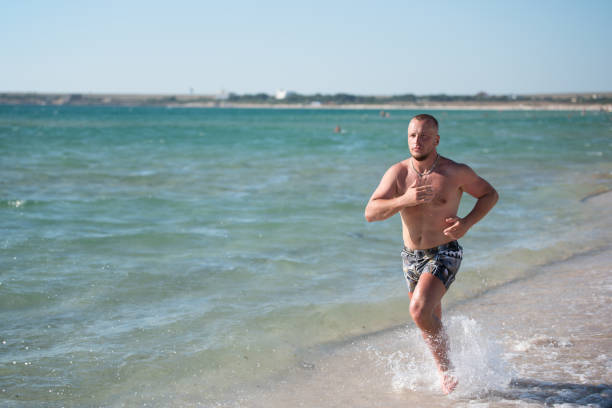 istock Man in motion of running on beach 843513676