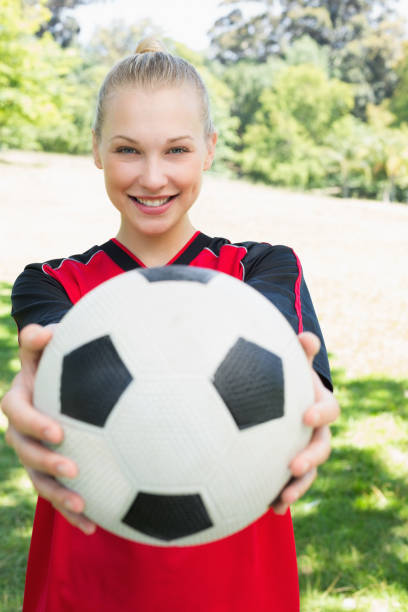 istock Beautiful soccer player showing ball at park 843513964