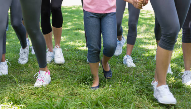 Females participating in breast cancer campaign Low section of women and girl participating in breast cancer campaign in park walking for a cause stock pictures, royalty-free photos & images