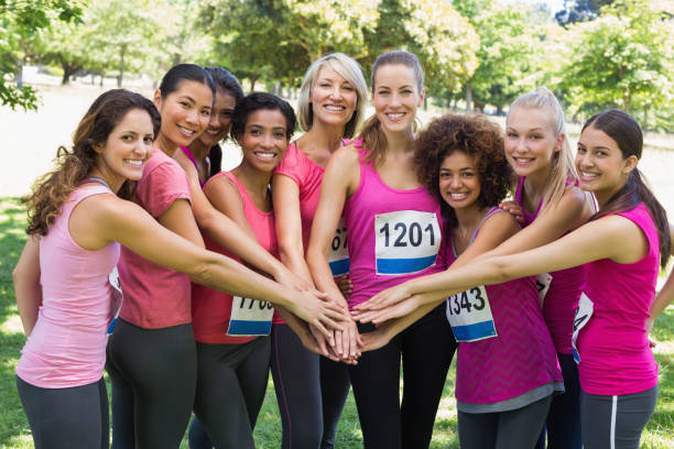 istock Female breast cancer marathon runners stacking hands 843514464