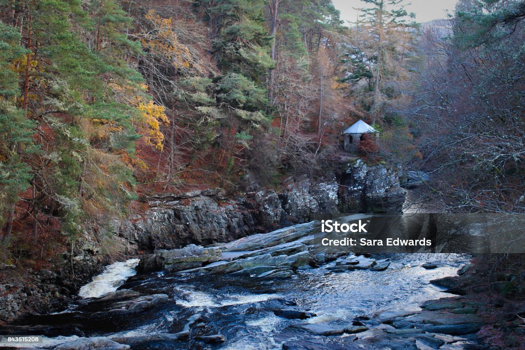 Idyllic Scottish Forrest Landscape with water and hut Perfect picturesque view of a stream and small cottage in Invermoriston in the Scottish Highlands with gorgeous fall foliage. Loch Ness Stock Photo