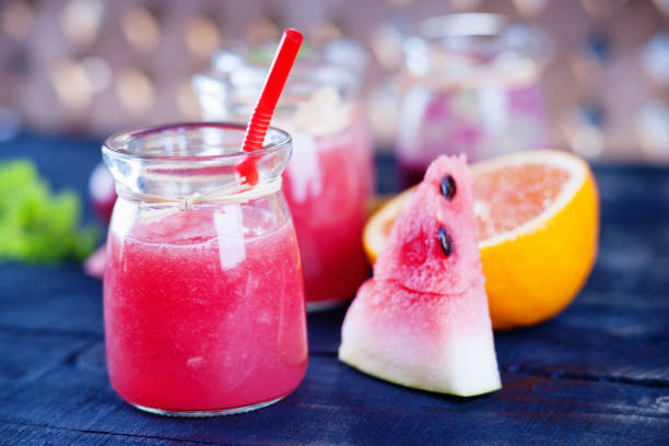 Jars with smoothies and fruits on a wooden table