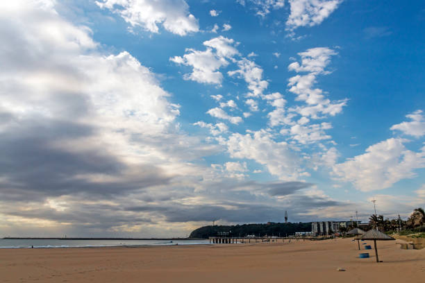 istock Early Morning Beach Against Bluff and Blue Cloudy Skyline 843521866