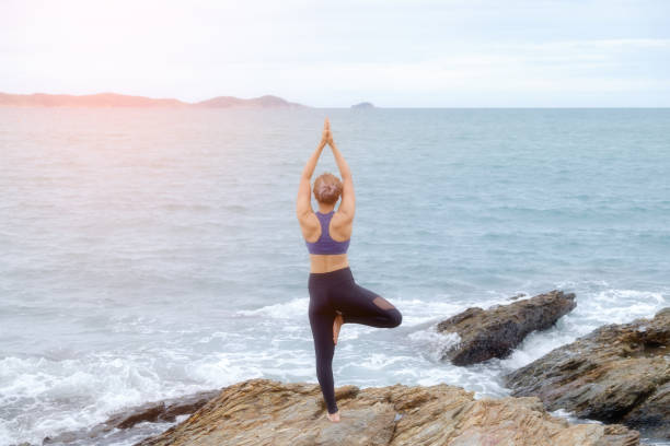 istock The woman practicing yoga on the beach at sunset. 843526106
