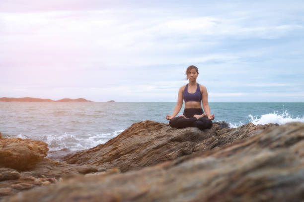 istock The woman practicing yoga on the beach at sunset. 843526110