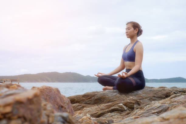istock The woman practicing yoga on the beach at sunset. 843526112