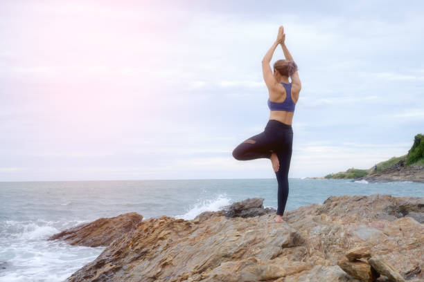 istock The woman practicing yoga on the beach at sunset. 843526118