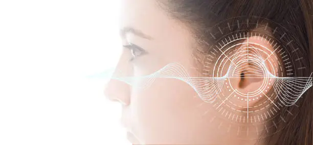 Photo of Hearing test showing ear of young woman with sound waves simulation technology