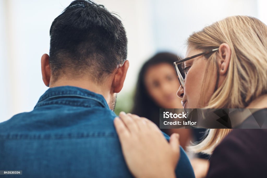 I know it hurts and I'm here for you Shot of a wife consoling her husband during a counseling session with a therapist Support Stock Photo