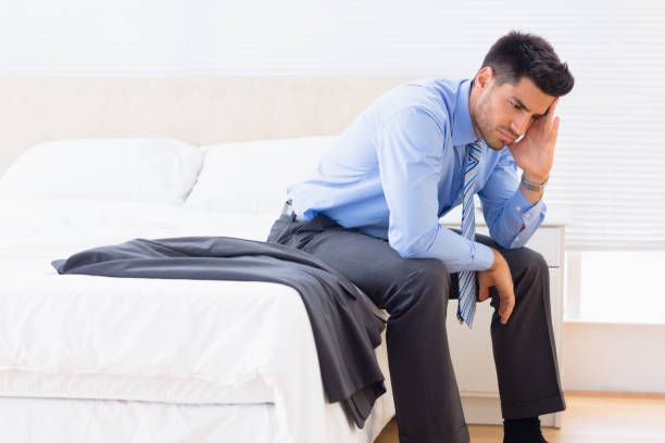 istock Frowning businessman sitting at edge of bed 843533304