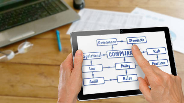 Tablet with Hands Researching Compliance stock photo