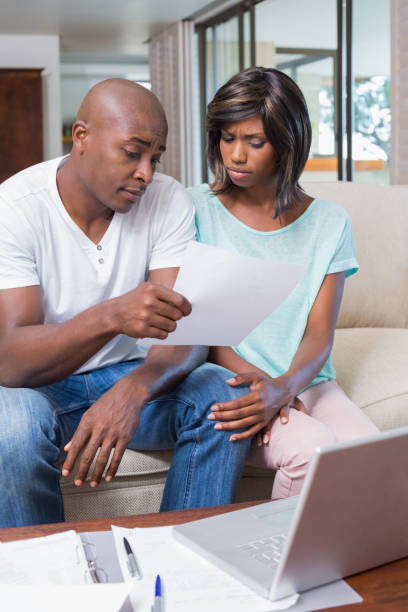istock Worried couple calculating bills on the couch 843534632