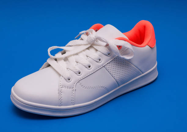 istock White sneakers isolated on blue background. Sport shoes. 843541698