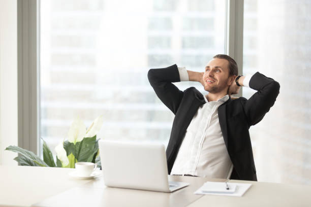 istock Happy smiling businessman relaxing at work desk in modern office. 843545390