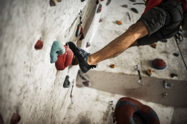 istock Unrecognizable male climber on a climbing wall in a gym. 843549358