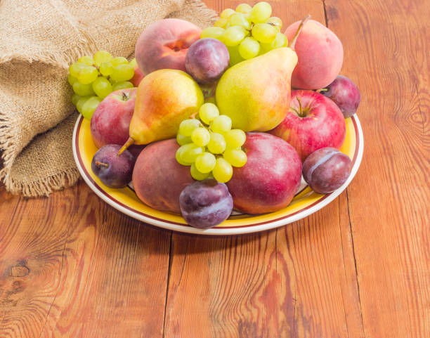 istock Different fruits on the big dish on a wooden surface 843550548