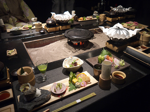Japanese kaiseki fushion meals for dinner, table with traditional hearth, glowing coals, personal dishes