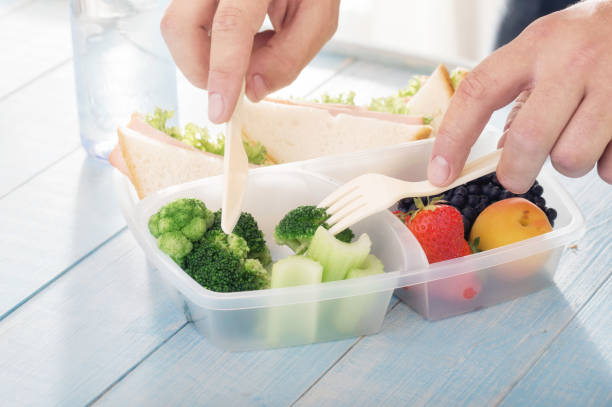 istock Young man eats a healthy meal from lunch box. Helpful Lunch concept 843554442