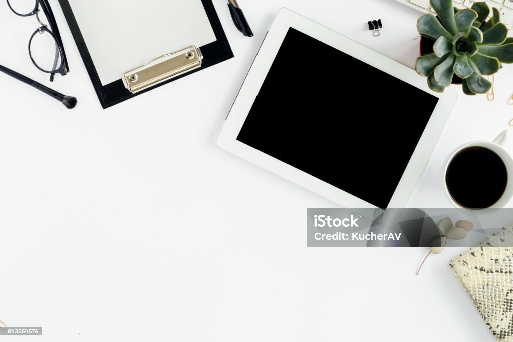 White tablet with clipboard, keyboard, notepad, glasses, succulents and cup of coffee. Office table desk. Top view White tablet with clipboard, keyboard, notepad, glasses, succulents and cup of coffee. Office table desk. Top view. Flat lay Template Stock Photo
