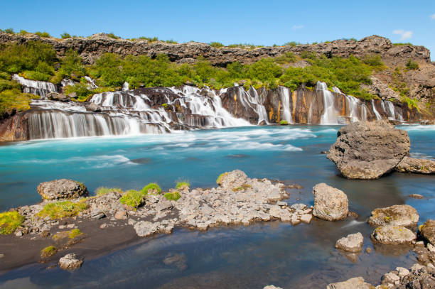 Hraunfossar Hraunfossar is a very beautiful Icelandic waterfall in the west of the island. It comes from the lava field and pours into the Hvita river with a incredibly blue water. Long exposure. hraunfossar stock pictures, royalty-free photos & images