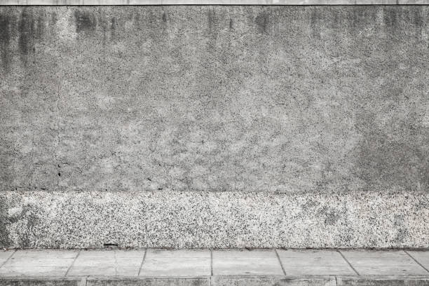 istock Gray grungy concrete wall and road pavement 843565032