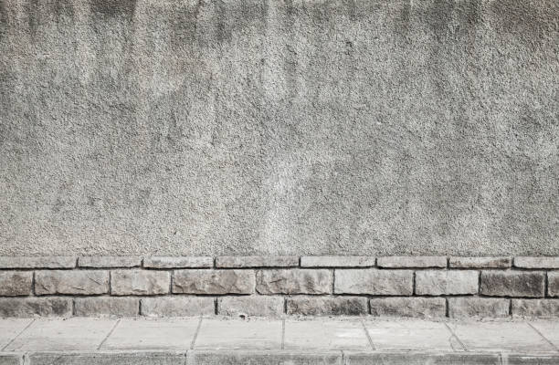 istock Gray grungy concrete wall and tiled road 843565034