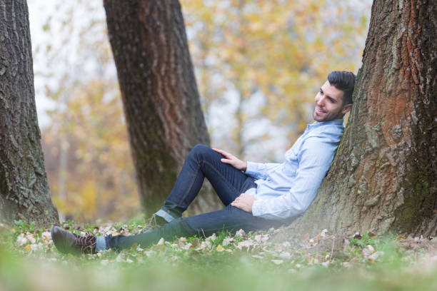 istock Handsome happy man in the park. Autumn scenery 843570012