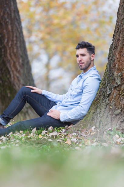 istock Handsome sad man in the park. Autumn scenery 843570072