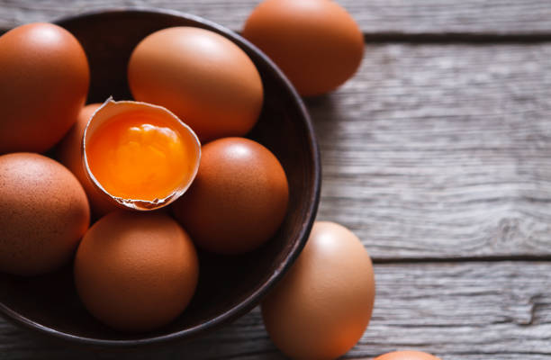 istock Fresh brown eggs in bowl on wood background 843577528