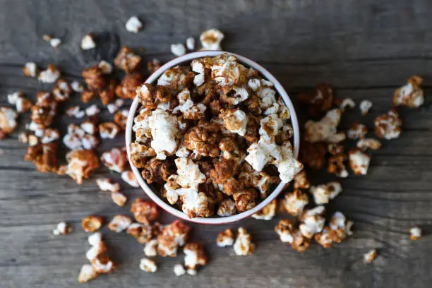 Photo of chocolate caramel popcorn on wooden background