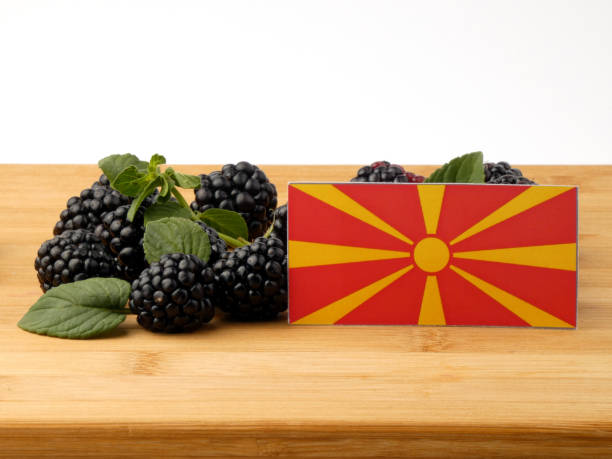 istock Macedonian flag on a wooden panel with blackberries isolated on a white background 843581130