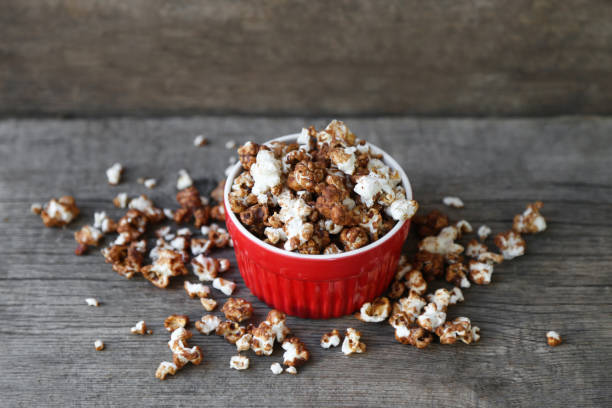 chocolate popcorn in red dish chocolate popcorn in a red dish popcorn snack bowl isolated stock pictures, royalty-free photos & images