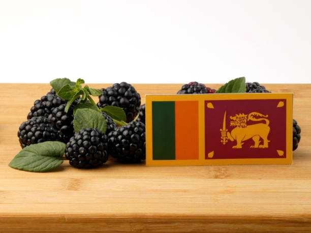 istock Sri Lankan flag on a wooden panel with blackberries isolated on a white background 843582340