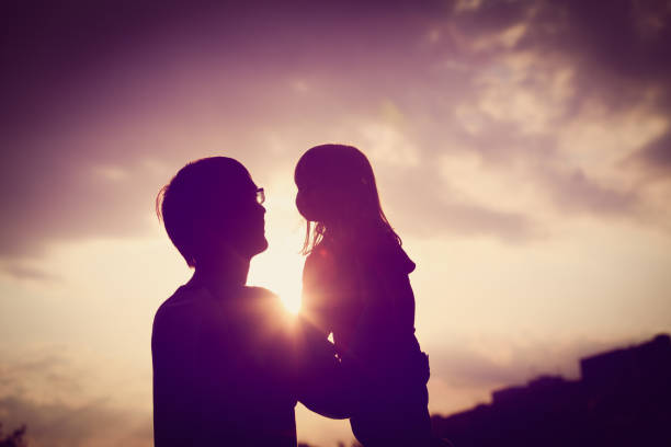 istock Father and little daughter silhouettes at sunset 843582804