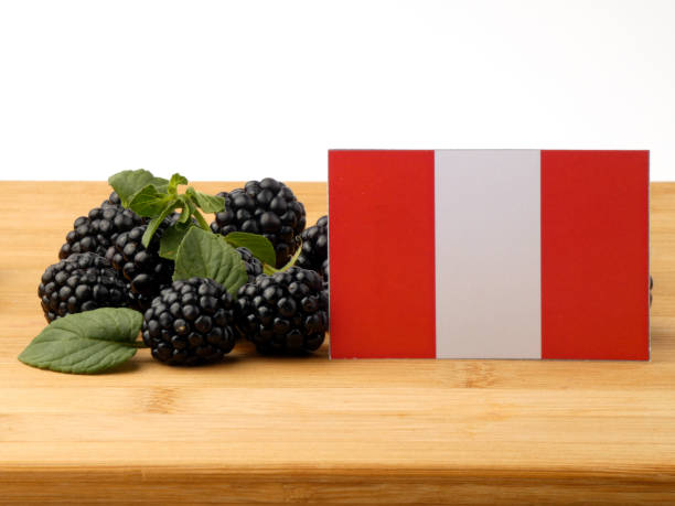 istock Peruvian flag on a wooden panel with blackberries isolated on a white background 843583320