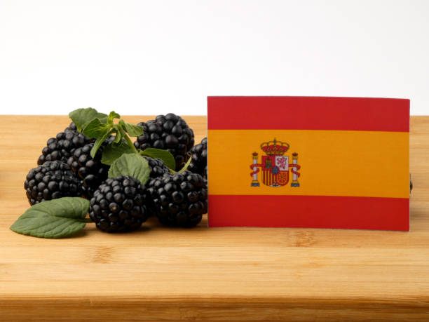 istock Spanish flag on a wooden panel with blackberries isolated on a white background 843585892