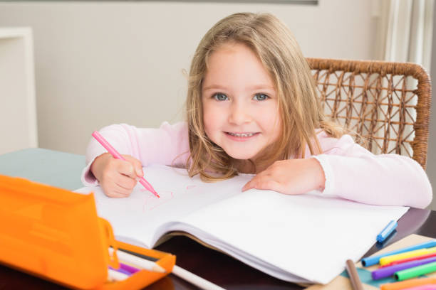 istock Happy little girl colouring at the table 843586086