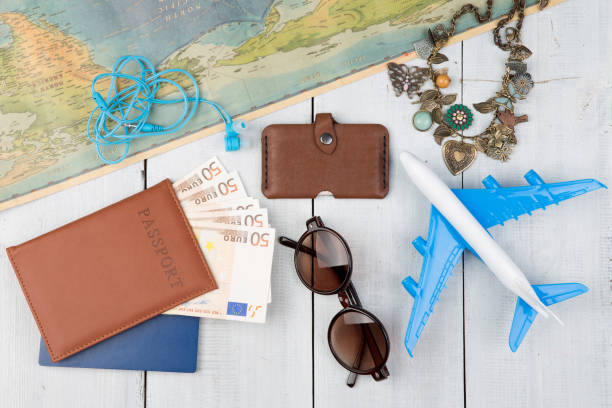 istock plane, map, passport, money, wallet, sunglasses on white wooden table 843586120