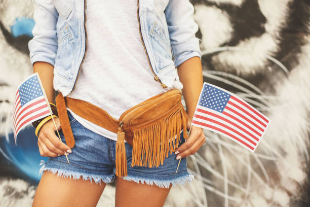 istock Girl holding two little american flags 843590362