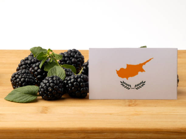 istock Cypriot flag on a wooden panel with blackberries isolated on a white background 843590736