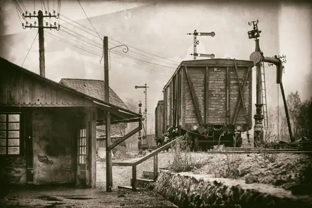 Old railway station with vintage cars and semaphores on the tracks stylized under a photograph on the glass