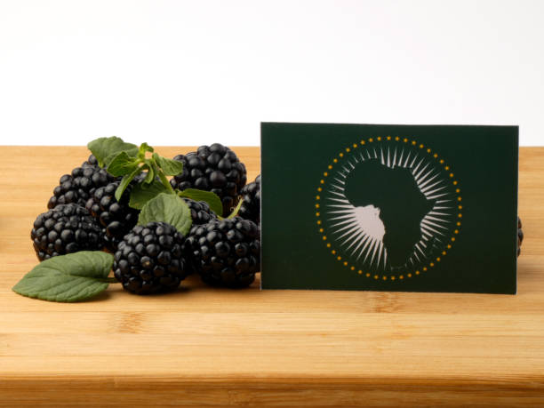 istock African Union flag on a wooden panel with blackberries isolated on a white background 843591204