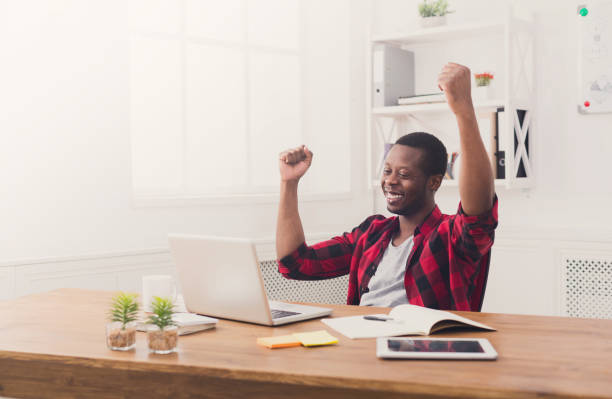 istock Happy businessman win. Winner, black man in office 843591450