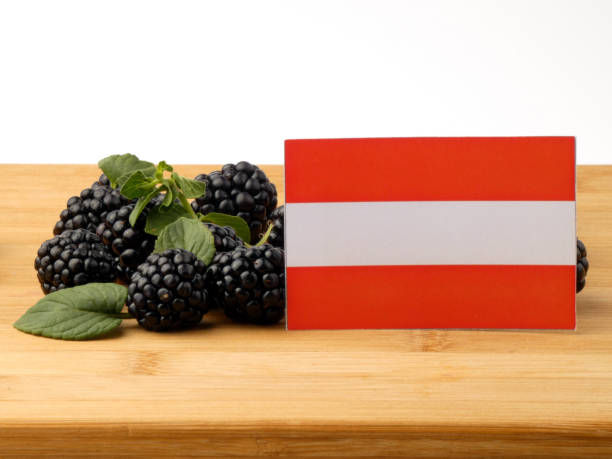 istock Austrian flag on a wooden panel with blackberries isolated on a white background 843593696