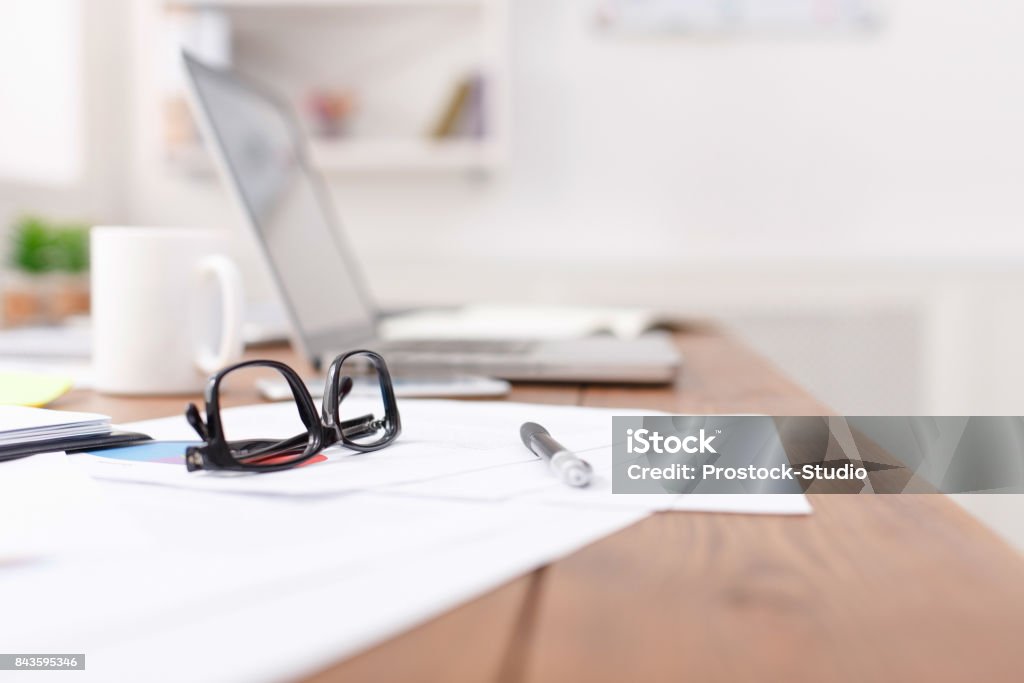 Seitenansicht der Schreibtisch mit Brille, Laptop und andere Gegenstände - Lizenzfrei Schreibtisch Stock-Foto