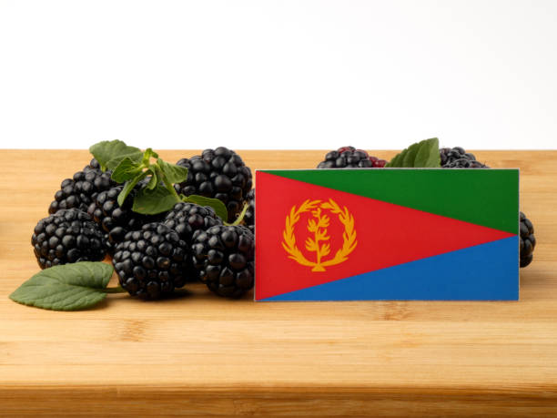istock Eritrean flag on a wooden panel with blackberries isolated on a white background 843599132
